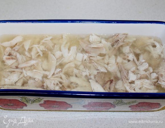 Сверху майонезной прослойки выкладываем кусочки мяса. Заливаем мясо прозрачным куриным желе. И снова ставим слой для застывания.