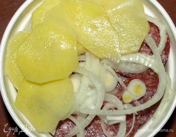 Сверху выкладываем еще один слой картофеля, солим, перчим, смазываем маслом. Еще один слой салями и лука. 