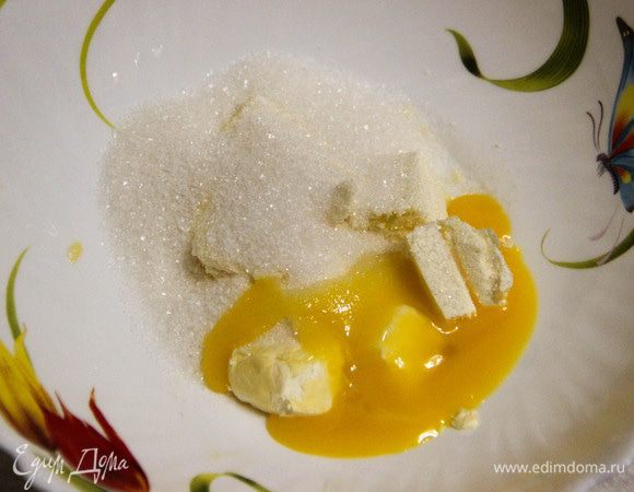 Сливочное масло нарезаем кубиками. Добавляем сахар, один желток (белок припасем для суфле).
