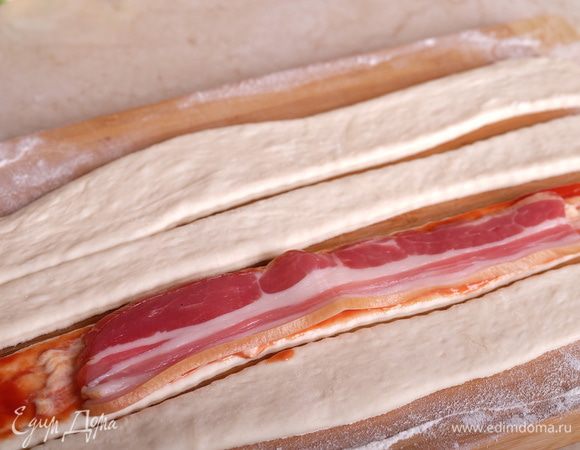 Сверху выкладываем полоску сырокопченого бекона.