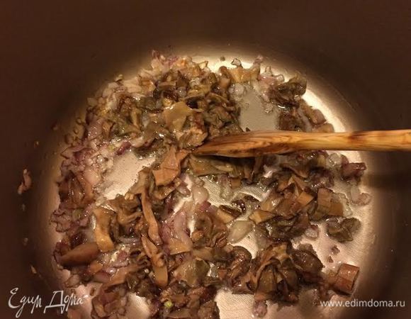 В кастрюле потушить лук, добавить белые грибы, перемешать, накрыть крышкой и тушить 5 минут.
