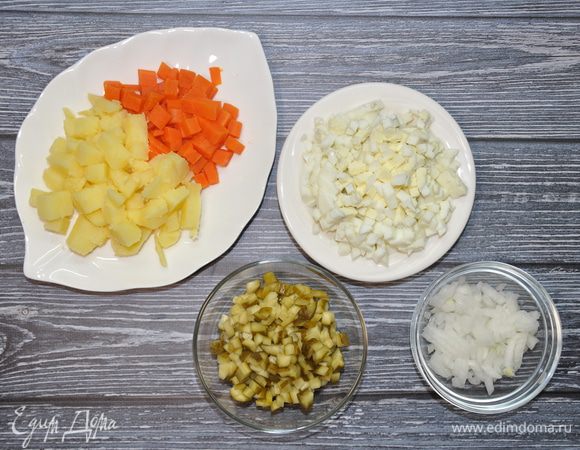 Картофель и морковь нарежьте средними кубиками. Соленые огурцы, лук и яйца мелко покрошите.