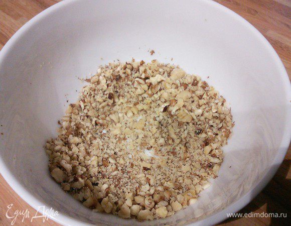 Мелко порубить орехи, поместить их в глубокую пиалу. 