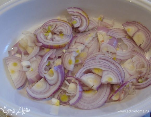 Лук нарежьте полукольцами и выложите в форму, полейте оливковым маслом.