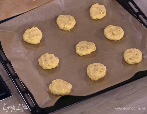 Сформировать из теста небольшие лепешки и выложить на противень, выстеленный пищевой бумагой.