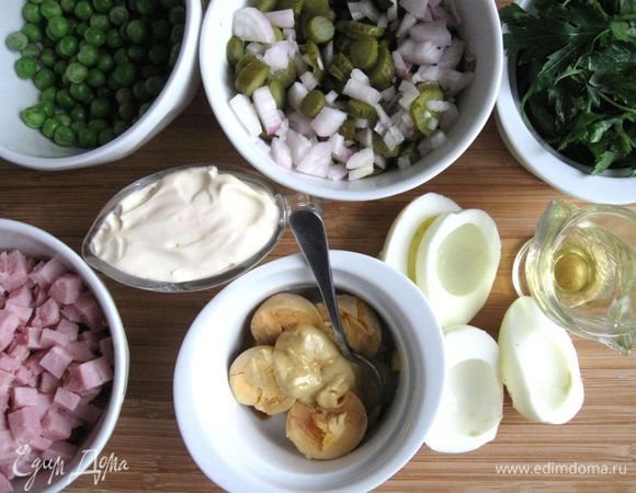 Яйца сварить вкрутую. Очистить, нарезать пополам, отделить белок от желтка. Желток смешать с горчицей и соевым соусом до однородности. Лук смешать с корнишонами, нарезанными колечками, каперсами. Корнишоны (в отличии от соленых, свежих или больших маринованных огурцов) дают мало жидкости в салате. Ветчину нарезать кубиками. Зелень петрушки помыть, обсушить.