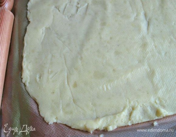 Остывший картофель разместить на бумагу для выпечки, придать ему прямоугольную форму, накрыть бумагой для выпечки, слегка прокатать скалкой. Снять верхний слой бумаги.