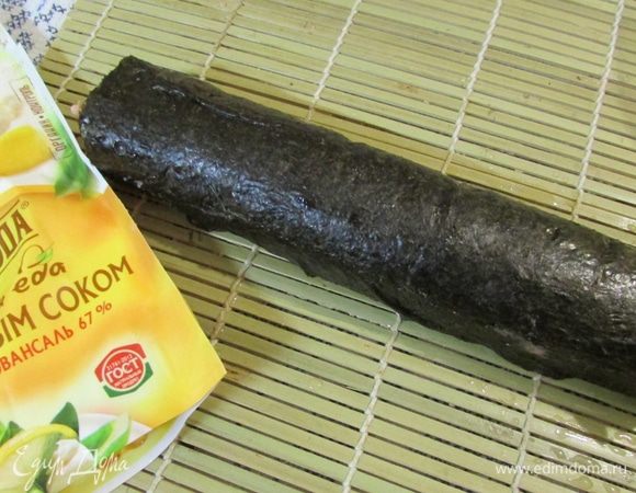 Смочить края нори водой и постараться свернуть массу в плотный рулет.