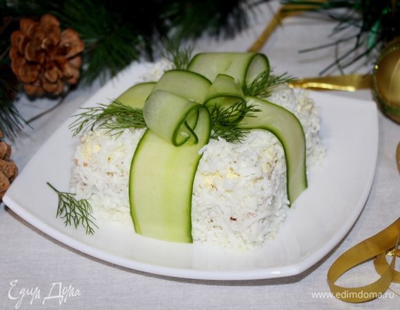 Огурец нарежьте тонкими полосками овощечисткой, «перевяжите» салат, имитируя ленту. Украсьте укропом или петрушкой.