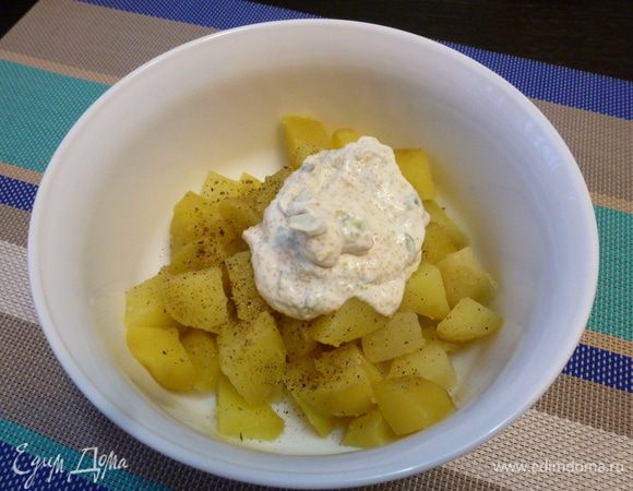 Вареный картофель нарежем крупными кубиками и добавим к нему половину заправки. Перемешаем и оставим на полчаса пропитаться.