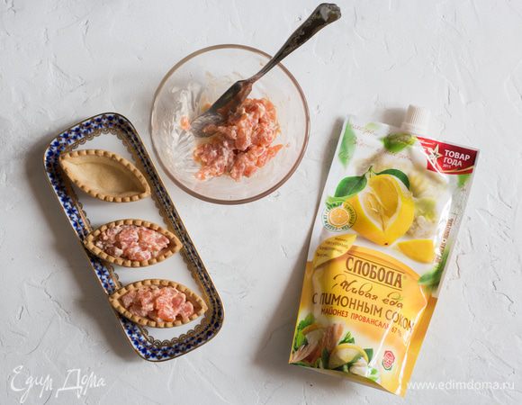 Аккуратно выложите в каждую тарталетку начинку. Сверху выложите красную икру и подавайте.