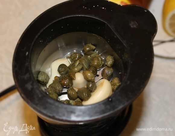 В блендер положите каперсы, чеснок и укроп, тщательно измельчите. 