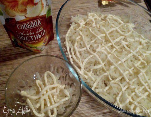 Приступаем к сборке салата. Салат можно сделать порционно или на одном общем блюде. 
Первым слоем выкладываем картофель, натертый на крупной терке, и смазываем майонезом.
