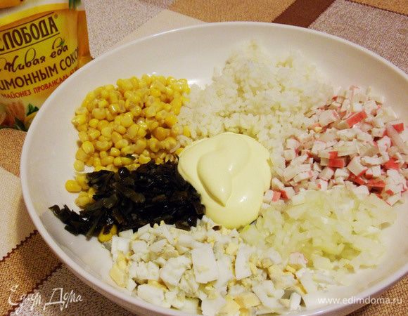 В миске смешать отварной рис, крабовые палочки, лук, яйца, консервированную сладкую кукурузу и морскую капусту. Добавить майонез.