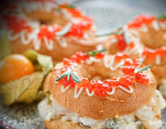 Фаршируем разрезанные пополам кольца салатом, украшаем сеточкой из майонеза, икрой и зеленью.