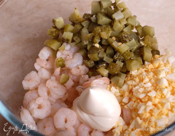 Соединяем вместе креветки, нарезанные кубиком огурцы, нарубленные яйца и майонез. Перемешиваем.
