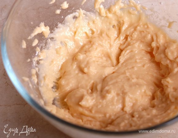 Приготовим простое заварное тесто. Масло нарезаем кубиком, добавляем в воду, засыпаем туда же соль и сахар. Ставим на огонь и доводим до кипения. Снимаем с огня, всыпаем муку и перемешиваем. Снова ставим на огонь и завариваем тесто, перемешиваем в течение 2 минут. При этом тесто должно собраться в комок, а на дне появится белая корочка. Перекладываем тесто в миску и добавляем по одному яйца, каждый раз хорошо вымешивая деревянной ложкой. Пятое яйцо вводим понемногу, добиваясь такой консистенции, что тесто стекает с ложки, но с усилием.