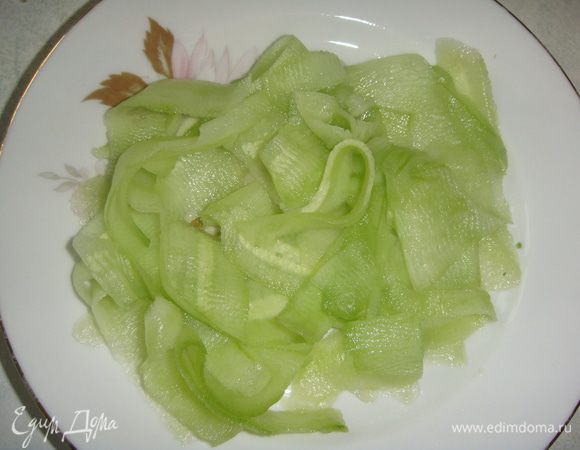 Огурец почистить и тонко нарезать пластинками. Я режу овощечисткой, так он получается очень тонким. Убрать лишнюю жидкость бумажным полотенцем.