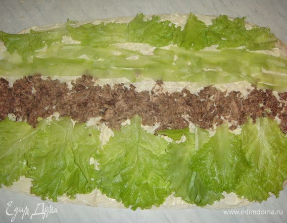 Листья салата помыть и обсушить. Выкладываем на лаваш листья салата, тунец, огурцы, листья салата. Заворачиваем лаваш в рулет со стороны огурца.