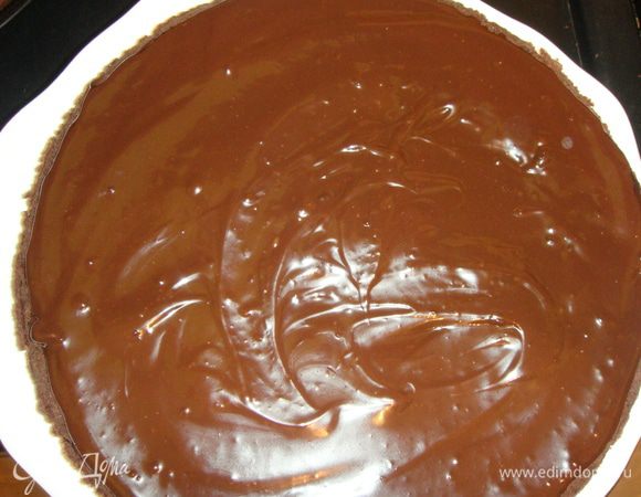 Выливаем шоколад на один корж и распределяем его по поверхности.