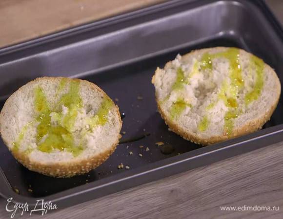 Булочки разрезать вдоль пополам, сбрызнуть оставшимся оливковым маслом и запечь под разогретым грилем.