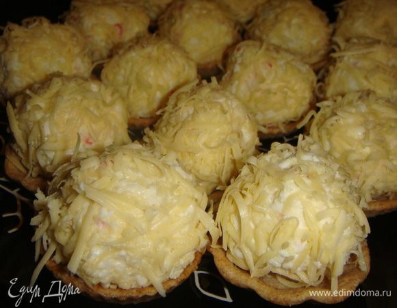 Обвалять шарики в тертом сыре и положить в тарталетки.