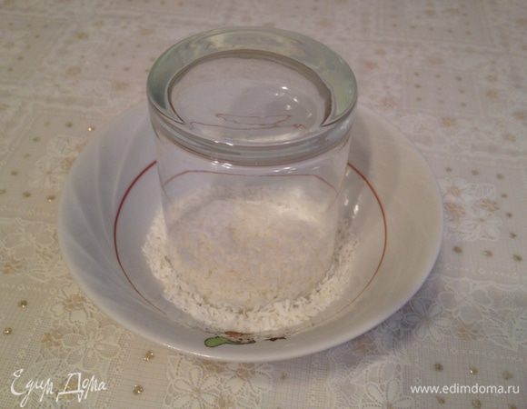 Край стакана окунуть в воду, а затем опустить в кокосовую стружку.