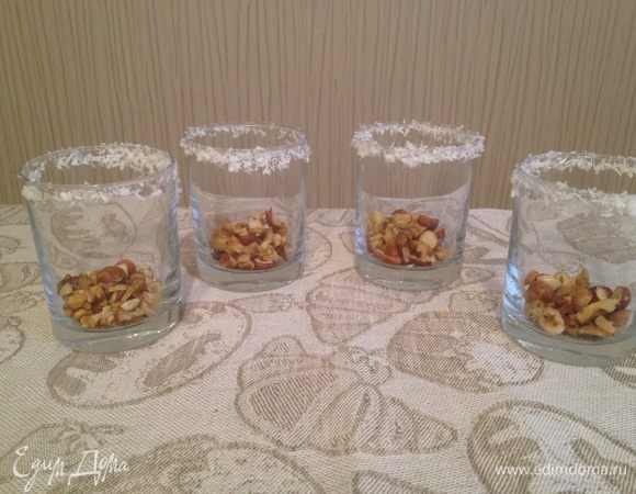 Орехи крупно нарезать и насыпать на дно стаканов.