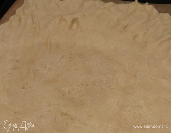 Расплескиваем половину  теста на противне с пергаментом. Накалываем тесто вилкой.