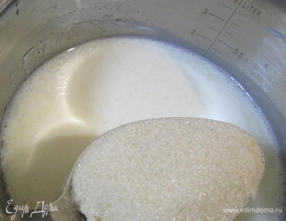 Слегка подогреть кефирную смесь. Затем добавить сахар, хорошо размешать.