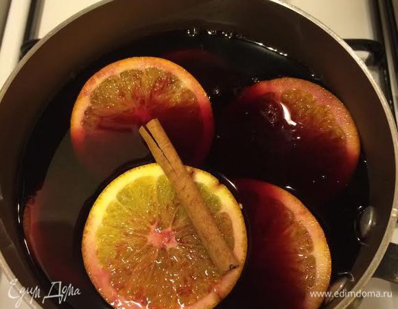 В ковшик влить вино, отвар, добавить сахар, апельсин и поставить на медленный огонь. Довести до кипения и снять с огня.