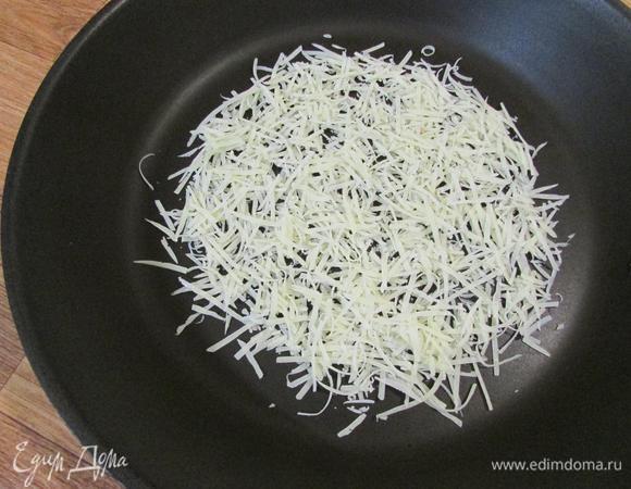 Сыр тонким слоем выложить на сухую сковороду. На среднем огне расплавить сыр. Аккуратно перевернуть сырную лепешку (осторожно, очень горячо!) на другую сторону. И подержать еще пару минут. Снять сырный корж со сковороды.