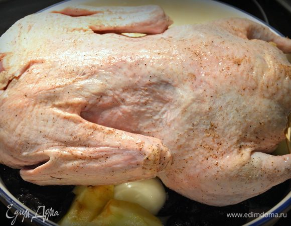 Духовку разогреть до 90 — 100°С. Яблоки помыть, почистить от кожуры и разрезать на 4 части. 4 — 6 штук оставить с кожурой. Чернослив помыть, лук почистить и разрезать пополам. Начинить утку яблоками и закрепить зубочистками или зашить кулинарными нитками. В блюдо выложить оставшиеся чищенные яблоки с черносливом и лук. Сверху положить утку, тушкой вниз. По краям выложить по 2 — 3 целых яблока.