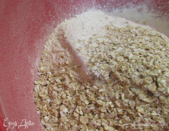 В миске смешать муку и овсяные хлопья.