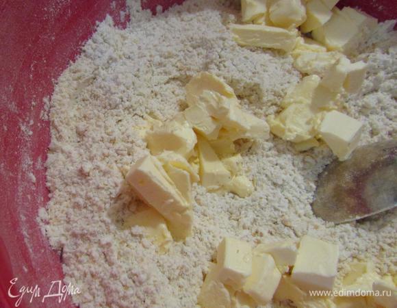 Сливочное масло комнатной температуры порезать небольшими кусочками и добавить к муке.