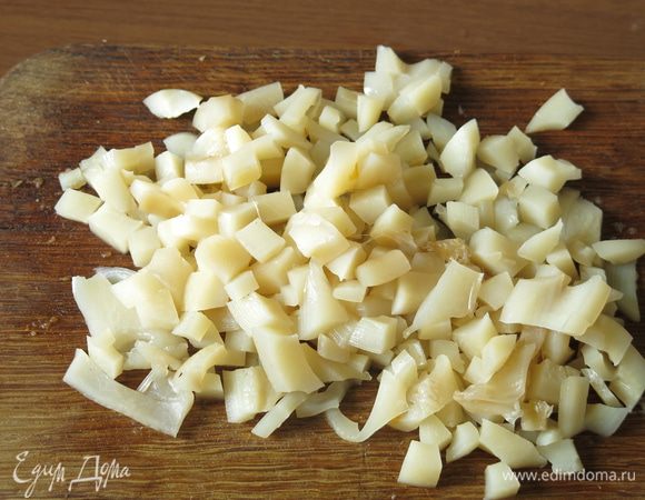 Отвариваем кальмар с укропом, 5 минут в кипящей воде. Снимаем кожицу, вынимаем пластинку. Нарезаем кальмар кубиками.