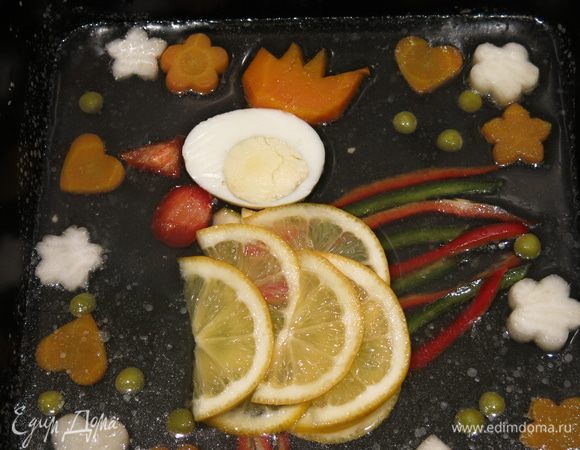 Выкладываем петушка аккуратно, пересмотрела множество оформлений, выбрала лимонное. Тонкие ломтики лимона — тело, перец — хвост и лапки, яйцо — голова, перец красный — гребешок. Оформление — цветы и сердечки из дайкона и моркови, горошек зеленый. Низ картинки будет верхом закуски, срез перца должен быть сверху.