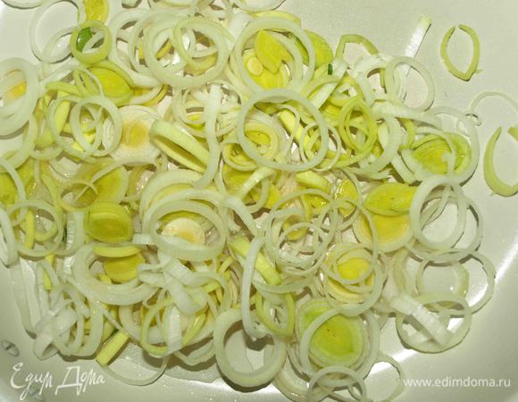 Разогреваем сковороду, добавляем растительное масло. Лук порей (белую часть) режем кольцами. Отправляем в сковороду и обжариваем, пока лук не станем мягким.