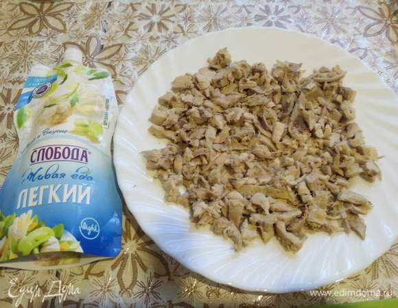 Курицу отделили от кожицы и костей, порезали мелко и распределили на блюде. Промазали майонезом.