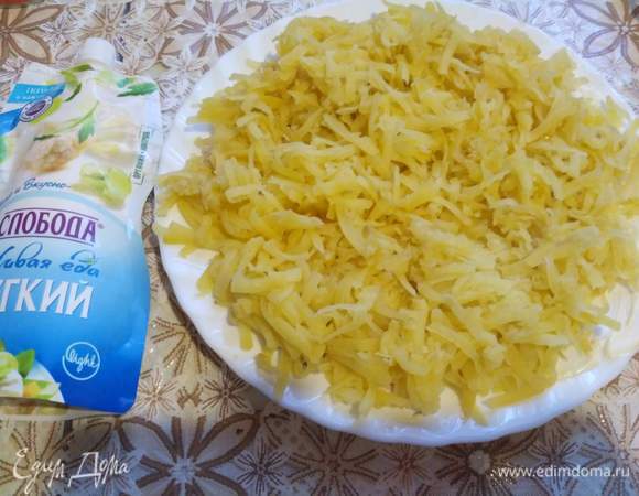 Картофель на крупной терке потерли, распределили на блюде и промазали майонезом.