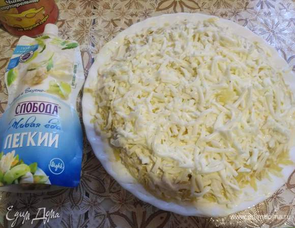 Белки на крупной терке потерли, распределили на блюде и промазали майонезом.