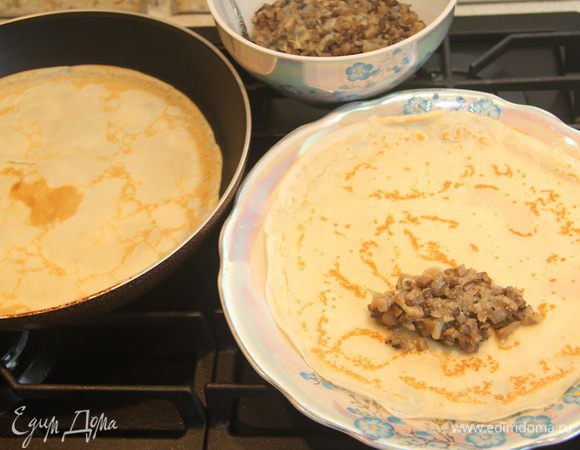 Блинчик начинить парой ложек жюльена, завернуть рулетиком, подогнув края с обеих сторон.