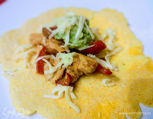 За столом каждый берет лепешку, выкладывает на нее фахитос, сдабривает гуакамоле, посыпает тертым сыром. 