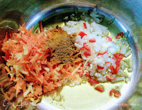 Прямо в кастрюле разогреть масло, выложить лук, чеснок, морковь, имбирь, зиру, куркуму, порошок перца чили. Пассеровать в течение нескольких минут. 