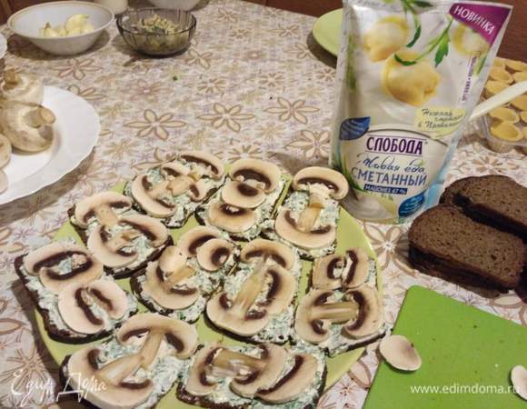 Поверх хлеба уложить тонко порезанные на дольки грибы сырые шампиньоны. Вкусные бутерброды готовы. Приятного аппетита!