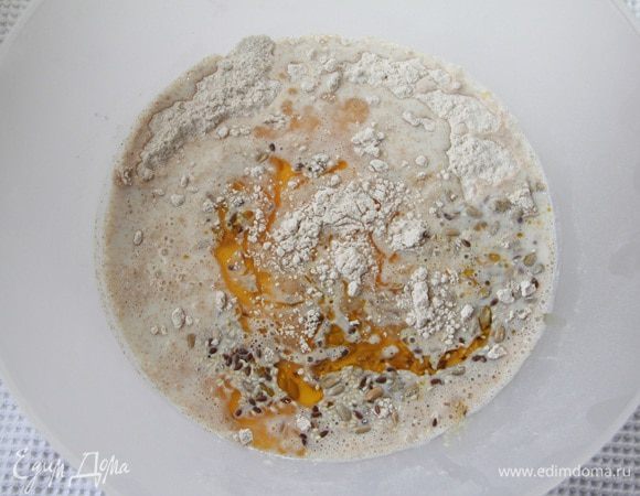 Половину яйца и половину порции семян оставить для оформления хлебцов. Соединить ингредиенты, замесить тесто. 