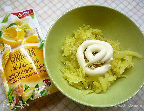 Отварной картофель натираем на крупной терке, приправляем по вкусу солью и перцем, добавляем 20 г майонеза и перемешиваем. Третью часть картофельной массы выкладываем ровным слоем на яичные рулетики и аккуратно разравниваем.