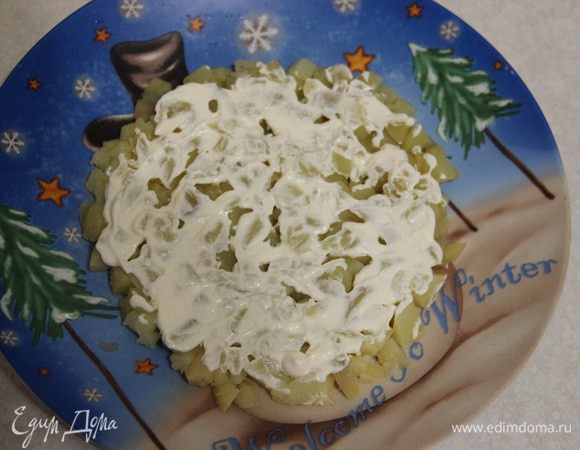 Салат будем выкладывать слоями. Первый: мелко нарезанный картофель. Покроем его сверху тонким слоем майонеза ТМ «Слобода» с лимонным соком.