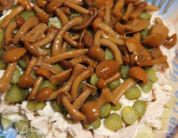 Далее нашинкованные корнишоны и маринованные опята. Покроем их также майонезом.