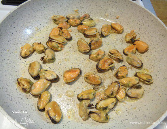 В воде из-под креветок отварить замороженные мидии (как только вскипят, вынуть) и спассеровать их немного на сковородке с оливковым маслом.